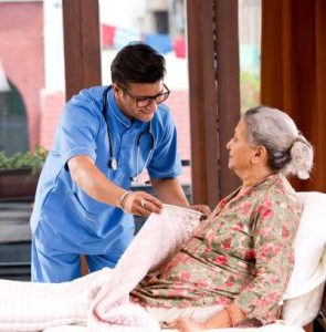 male nurse home caregiver helping senior woman relaxing on bed